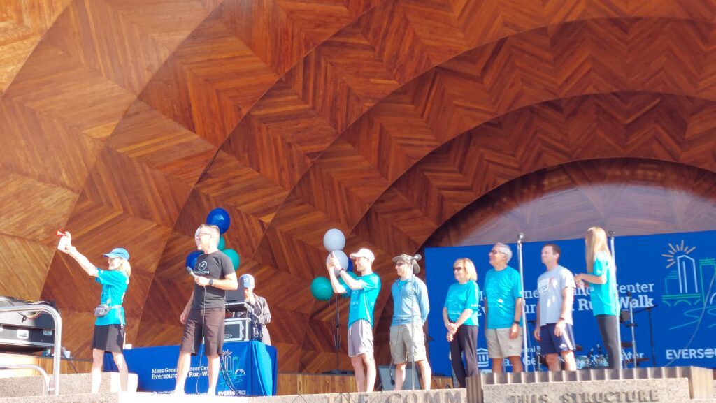 Brian's Team honored on stage at the 2024 Cancer 5K, blowing the horn to start the runners